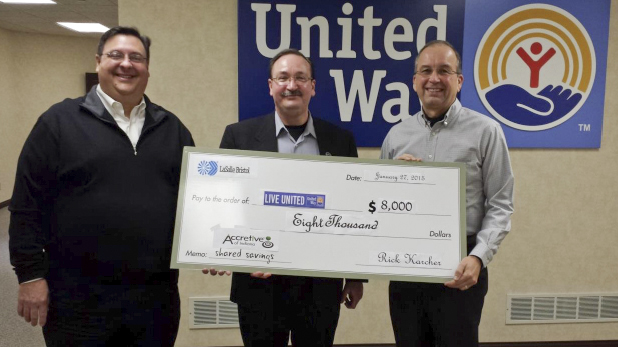Proto of Bill Rieth accepting a check on behalf of the nonprofit United Way of Elkhart County from Rick Karcer and Mark Hatley